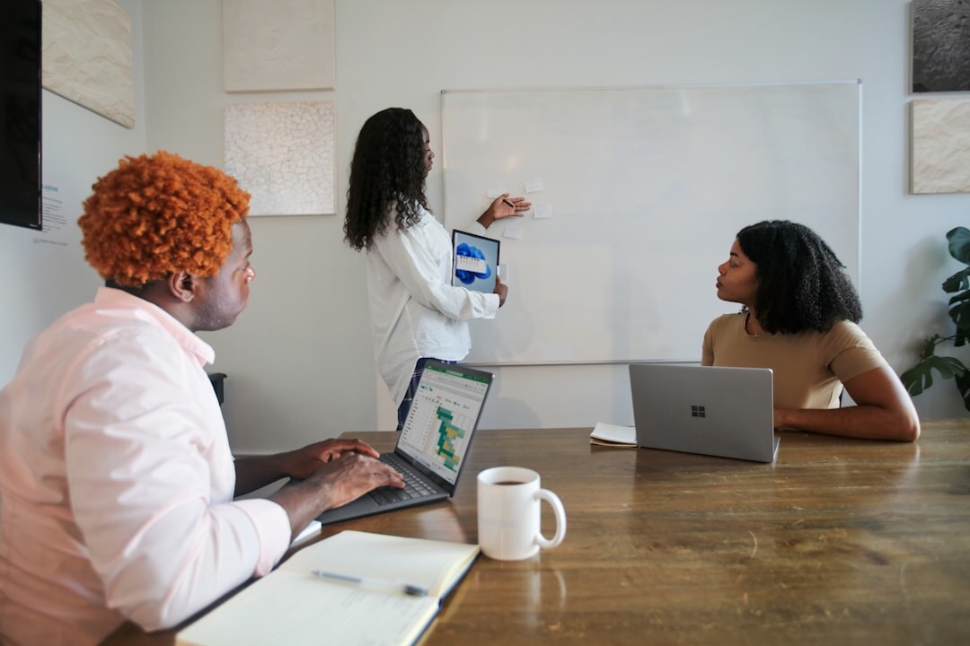 Diverse marketing team discussing strategy around a table with laptops and charts